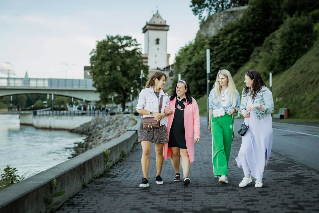 Sõbrannad Narva Jõepromenaadil jalutamas, taga paistab Narva linnus