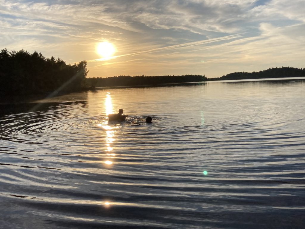 Uljaste järv päikeseloojangul ja inimesed vees