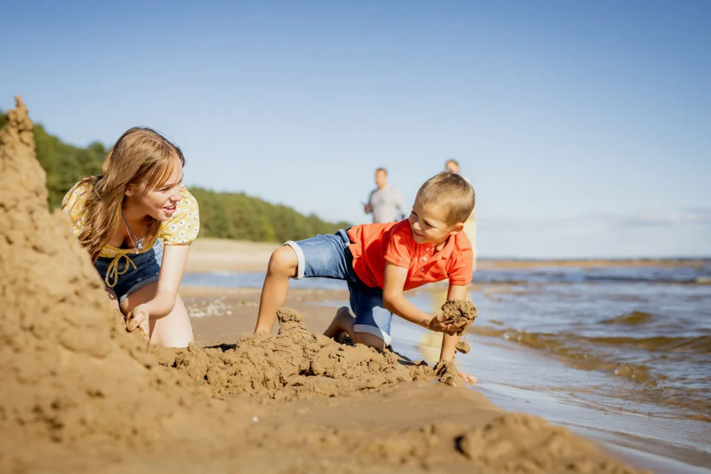 Kauksi rannas Peipsi järve ääres lapse ehitamas liivalosse