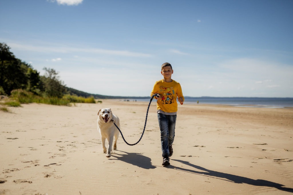 Narva-Jõesuu rannas poiss jooksmas koeraga